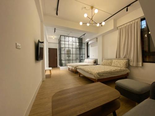 a living room with two beds and a table at One Day 有日-民生路一段207號 in Tainan