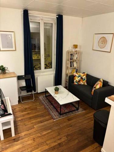 uma sala de estar com um sofá e uma mesa de centro em Appartement cosy proche métro em Ivry-sur-Seine
