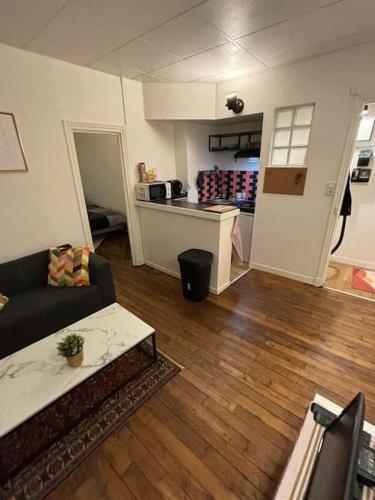 uma sala de estar com um sofá e uma cozinha em Appartement cosy proche métro em Ivry-sur-Seine