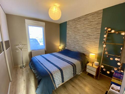 um quarto com uma cama e uma parede de tijolos em Maison chic avec Jacuzzi & Jardin Paisible em Chauray