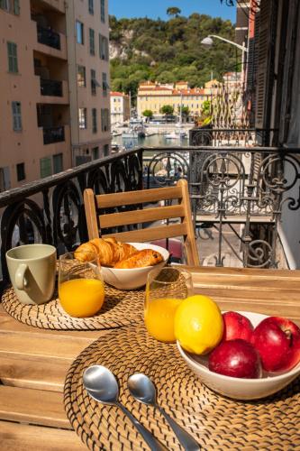 - une table avec des fruits et des oranges sur un balcon dans l'établissement Magnifique 2P avec vue sur le port de Nice, à Nice