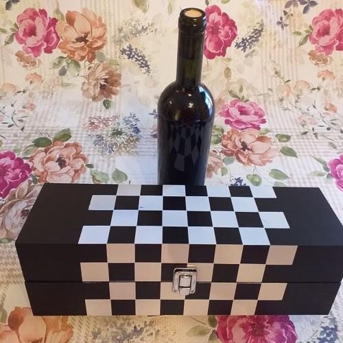 a bottle of wine sitting on top of a chessboard at HELLAS PALACE ROOMS balcony in Sparti