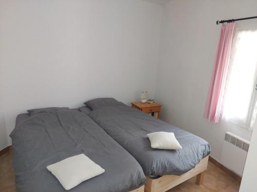 um quarto com uma cama com duas almofadas em Colchique em Le Mas