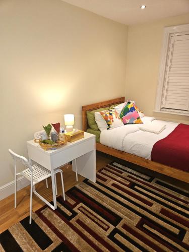 a bedroom with a bed and a desk and a table at LONDON HEATHROW GLAMOUR MANSION HOUSE in Uxbridge