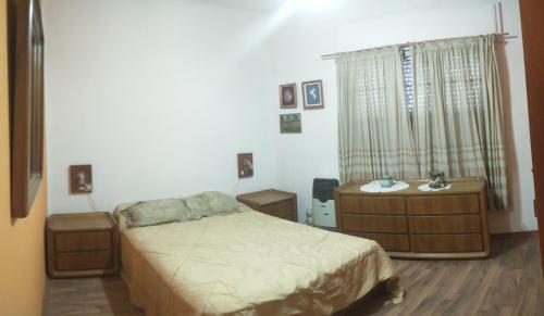 Departamento centro Boj في Deán Funes: غرفة نوم بها سرير و خزانتين و نافذة