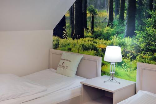 a bedroom with a bed and a table with a lamp at Malutkie Resort in Radomsko