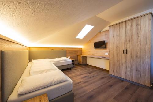 a bedroom with a large bed and a cabinet at Upside Down Town Hotel Neue Post in Zell am See