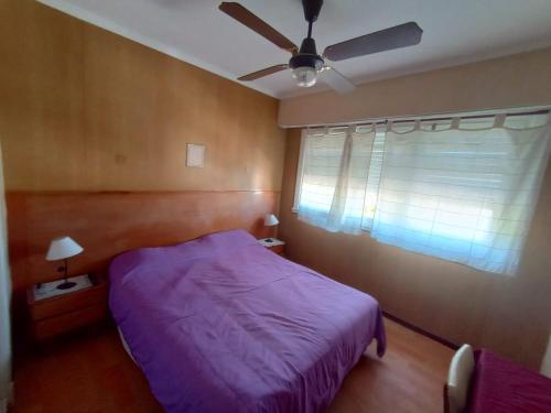 1 dormitorio con cama morada y ventilador de techo en Nuevo Hotel Tivoli en Mar del Plata
