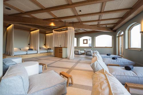 a large room with three beds and chairs and windows at Hotel Neue Post in Zell am See