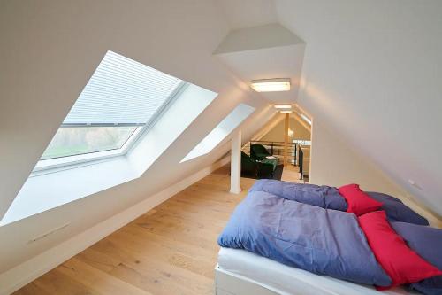 Zimmer im Dachgeschoss mit einem Bett und einem großen Fenster in der Unterkunft Ferienwohnung „Langer Jammer“ im Hesterhoff in Bad Zwischenahn