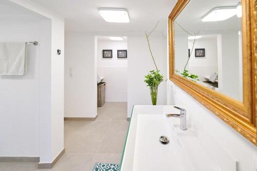 een badkamer met een wastafel en een spiegel bij Ferienwohnung „Langer Jammer“ im Hesterhoff in Bad Zwischenahn