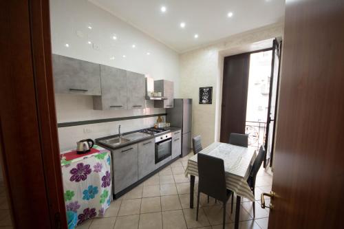 uma cozinha com uma pequena mesa e uma cozinha com uma mesa e cadeiras em Buona Napoli em Nápoles