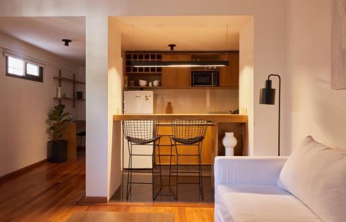 uma sala de estar com um sofá branco e uma cozinha em Hestia At Palermo Charming Studio W Balcony em Buenos Aires