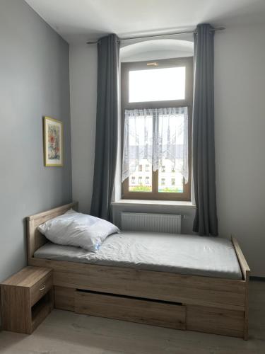 uma cama num quarto com uma janela em Zweizimmerwohnung am Markt em Finkenburg