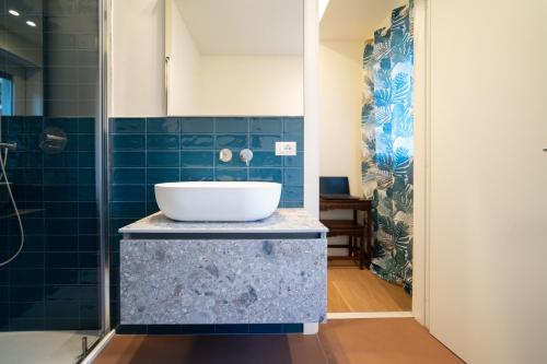 baño con lavabo y azulejos azules en Luxury Suite Sempione, en Milán