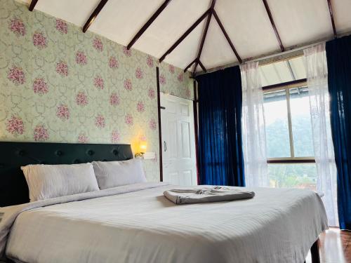 een slaapkamer met een groot bed en een raam bij Raymond's Holiday Homes in Vythiri