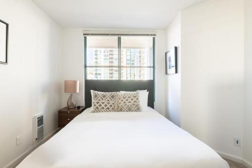 een slaapkamer met een wit bed en een raam bij South Beach 2br w heated pool shops dining SFO-1664 in San Francisco
