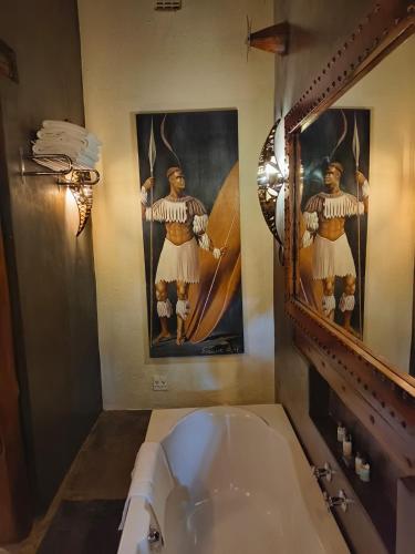 a bathroom with a sink and a mirror and a tub at Dar Amane Guest House in Graskop