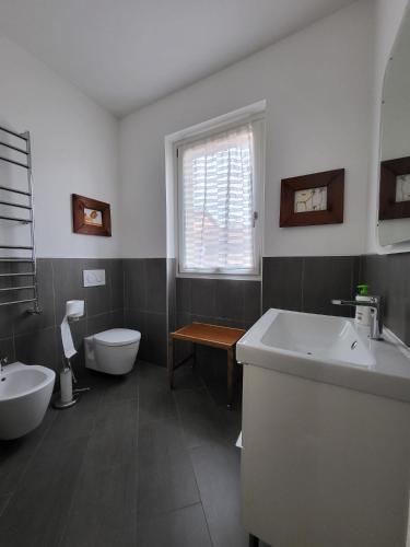 a bathroom with two sinks and a toilet and a window at Penthouse Federico with lake view - Residenza Silvana in Verbania