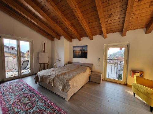 a bedroom with a large bed in a room with windows at Penthouse Federico with lake view - Residenza Silvana in Verbania