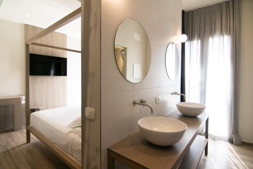 a bathroom with two sinks and a mirror at Hotel Hollywood in Rimini