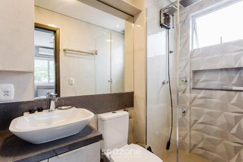 a bathroom with a toilet and a sink and a shower at Belo apartamento com design moderno ABZ302 in Florianópolis
