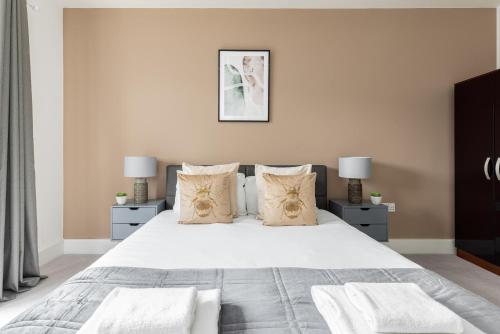 a bedroom with a large white bed with pillows at The Bridge Apartments in London
