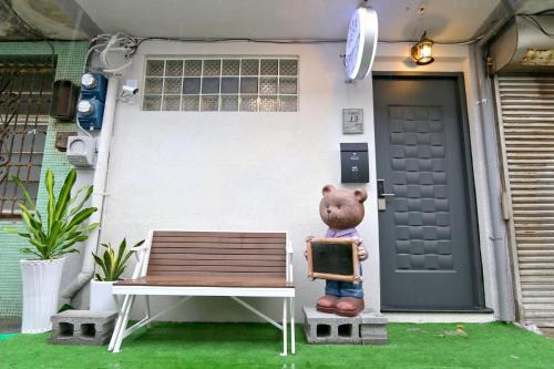 鹿港的住宿－鹿港谷倉民宿，坐在房子前面的长凳上的泰迪熊