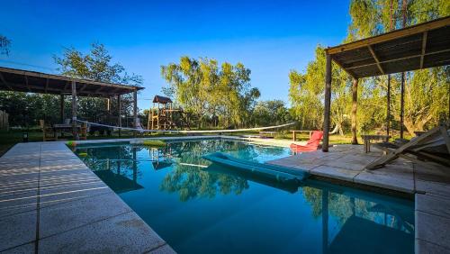 een zwembad met een speeltuin op de achtergrond bij Hermosa Casa con piscina 1400 metros in Carlos Keen