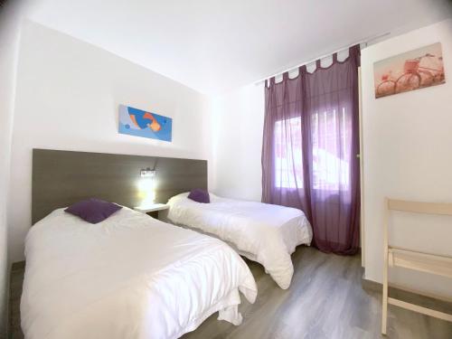 1 dormitorio con 2 camas y ventana en Eden mar, en Roses