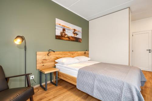 a small bedroom with a bed and a chair at TopFloor Apartments in Vilnius