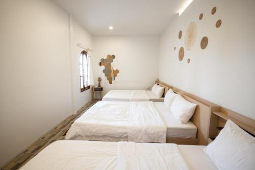 2 camas en una habitación con paredes blancas en Tawaen Beach Villa, en Koh Larn