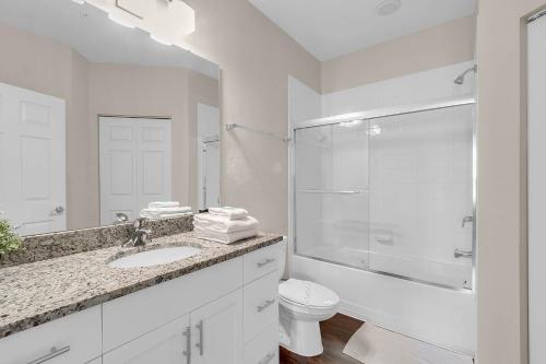 a white bathroom with a sink and a toilet at 4 Bedrooms - 3 Bathrooms - Lucaya Village 14-101 in Orlando