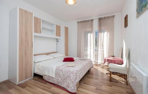 a bedroom with a bed and a large window at 3 Bedroom Beautiful Home In Rascane in Ožići