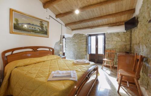 a bedroom with a bed with a yellow bedspread at 1 Bedroom Lovely Apartment In San Piero Patti in San Piero Patti