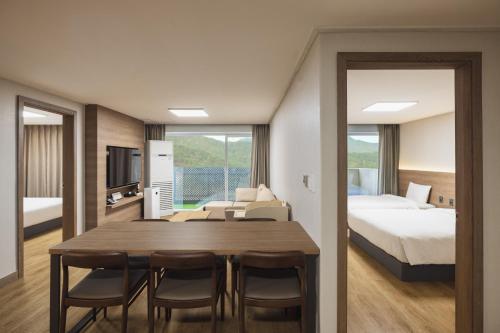 a room with a dining table and a bedroom at Kensington Resort Chungju in Chungju