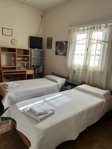 duas camas sentadas uma ao lado da outra num quarto em Casa Los Rosales, amplia, cómoda, excelente ubicación con cochera em Puerto Madryn