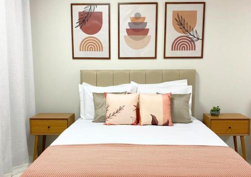 ein Schlafzimmer mit einem Bett mit vier Bildern an der Wand in der Unterkunft Terraço Naturale in Domingos Martins
