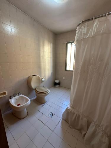 a bathroom with a toilet and a sink at Casa Los Rosales, amplia, cómoda, excelente ubicación con cochera in Puerto Madryn