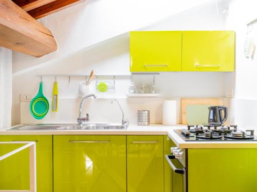 a kitchen with yellow cabinets and a sink at Casa Giulia - Appartamento a San Gimignano in San Gimignano