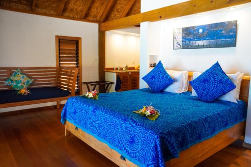 1 dormitorio con 1 cama azul en una habitación en Heaven to Sea Beach Villas, en Amuri