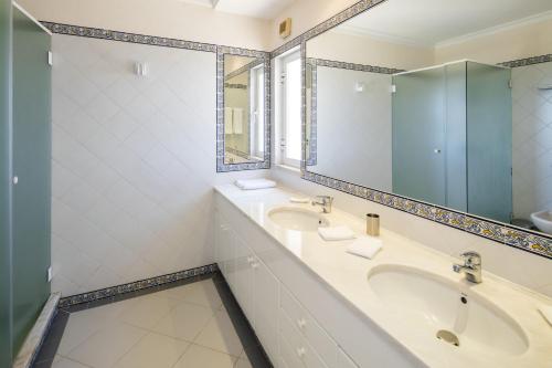 a bathroom with two sinks and a large mirror at Vale De Lobo Villa With Pool by Homing in Vale do Lobo