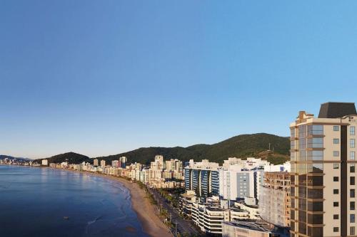 Blick auf eine Stadt mit Strand und Gebäuden in der Unterkunft Luxuoso apartamento com vista mar em Itapema SC in Itapema
