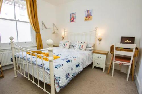 1 dormitorio con 1 cama blanca y 1 silla en Hendon Street Beach Huts en Brighton & Hove