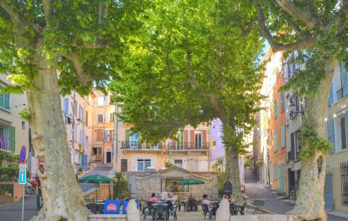 a city street with people sitting at tables under trees at Nice Apartment In Barjols With Wifi in Barjols