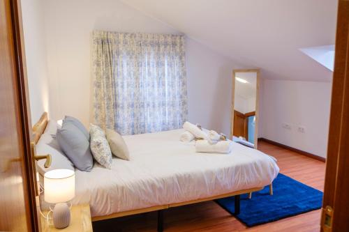 um quarto com uma cama com almofadas e um espelho em El Deseo de la Vega em El Burgo de Osma