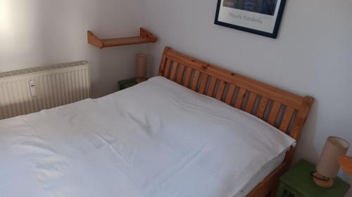 a bedroom with a bed with white sheets on it at Fewo Muschel incl Kurkarte Parkplatz und strandnah in Ahrenshoop