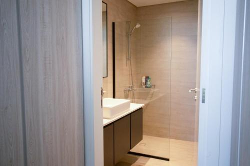 uma casa de banho com um lavatório e um chuveiro em We are 25 Mins to Downtown Dubai em Ḩiz̧āyib az Zānah