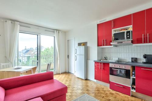 une cuisine avec des placards rouges et un canapé rouge dans l'établissement Lovely 1 BR Flat with balcony near metro line 10, à Boulogne-Billancourt