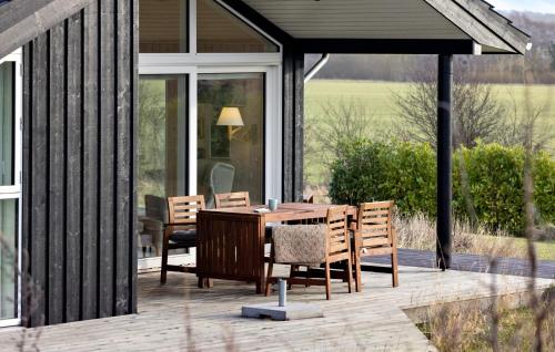 a wooden table and chairs on a patio at Stunning Home In Haarby With Kitchen in Hårby